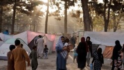 FILE - Displaced Afghan families, fleeing the violence in their provinces, stand near tents in a makeshift shelter in a park in Kabul, Afghanistan, October 4, 2021.
