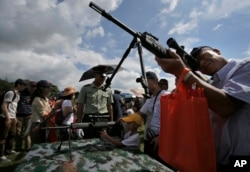 Visitors take aim with rifles at a military base during an open day event of the Chinese People's Liberation Army (PLA) in Hong Kong, June 29, 2014.