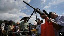 香港民眾參觀解放軍駐港部隊。人們紛紛觀看中國製造的解放軍使用的各類槍支。