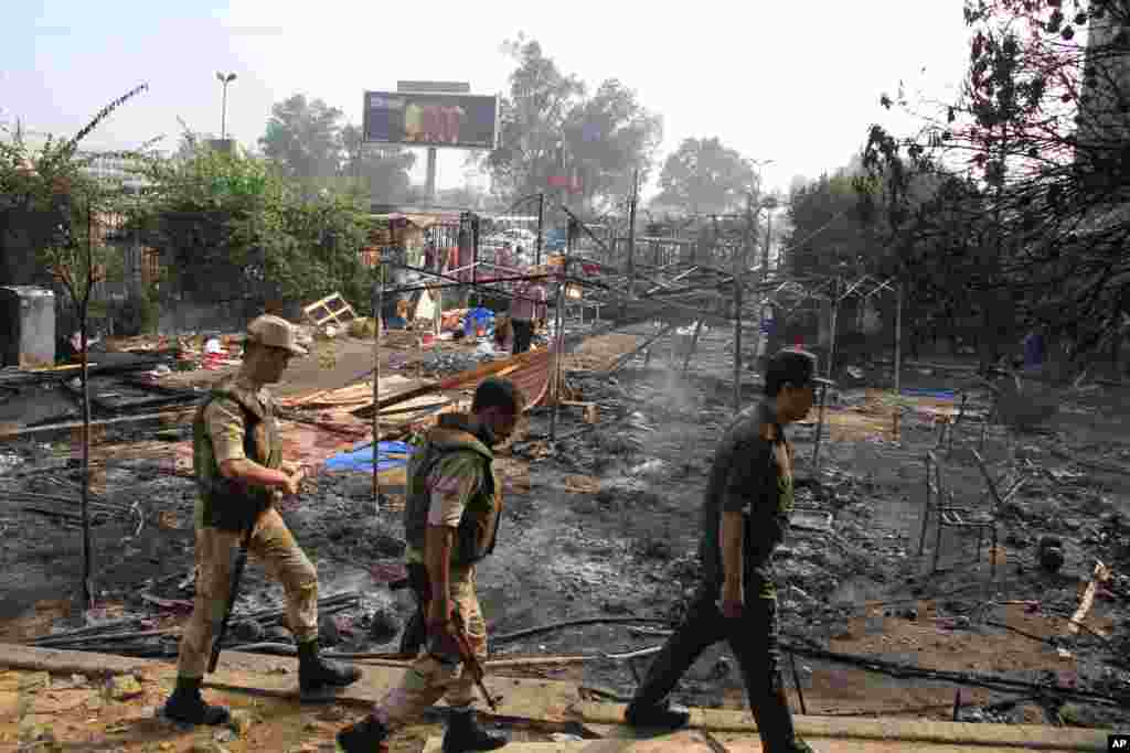 Members of the Egyptian Army walk among smoldering debris after the largest protest camp of Morsi supporters was cleared by security forces, Nasr city, Cairo, August 15, 2013.