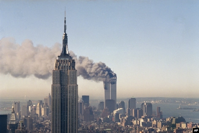 FILE - In this Sept. 11, 2001 photo, the twin towers of the World Trade Center burn behind the Empire State Building in New York after terrorists crashed two planes into the towers causing both to collapse.