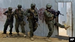 FILE - Somali soldiers search through homes for al-Shabaab fighters, during an operation in Ealsha Biyaha, Somalia, June, 2, 2012. On Tuesday, Somali forces attacked a base of the militant group north of Kismayo.