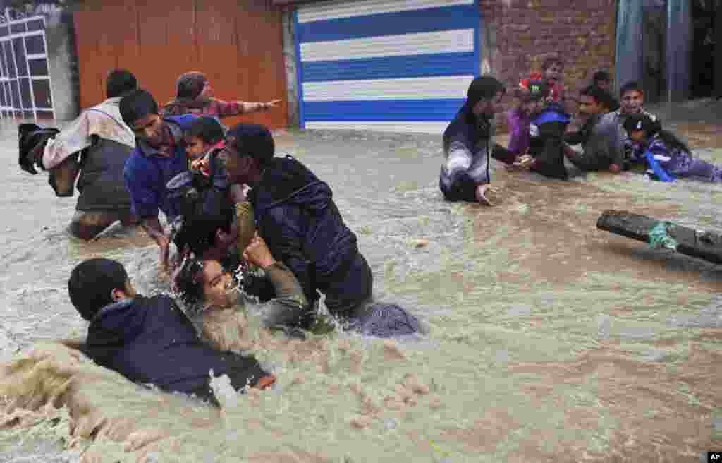 Kashmiri residents struggle to withstand sudden and strong water currents while wading through floodwaters in an effort to move to safer places in Srinagar, India.