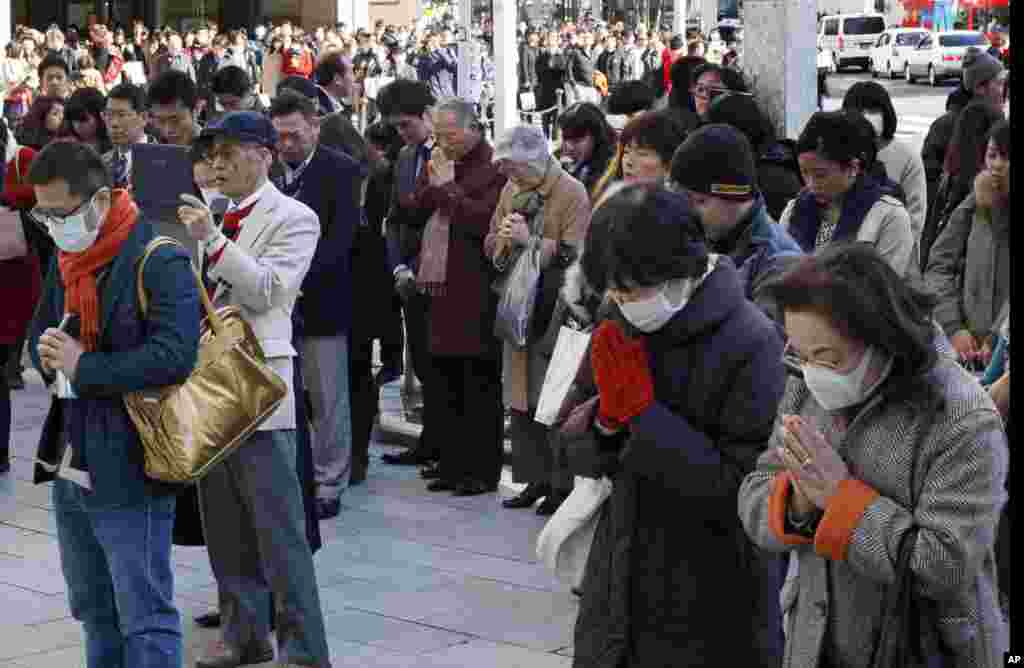 People offer prayers for the victims of the 2011 earthquake and tsunami as they observe a moment of silence at 2:46 p.m. when a magnitude 9.0 earthquake struck off Japan&#39;s northeastern coast four years ago, at Ginza shopping district in Tokyo, March 11, 2015.