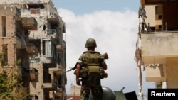 A Lebanese army soldier stands atop of an armored personnel carrier (APC) patrolling the area near a mosque complex where hardline Sunni cleric Sheikh Ahmed al-Assir was believed to be sheltering with his supporters, in Abra near Sidon, southern Lebanon, 