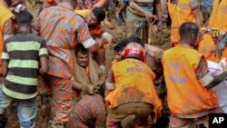 Rescuers pull out the dead body of a victim after Tuesday's massive landslide in Rangamati district, Bangladesh, June 14, 2017. 