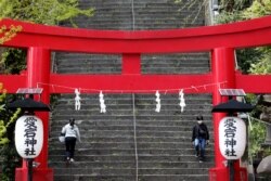 People walk on steps after the Japanese government announced a state of emergency for the capital and some prefectures following amid the coronavirus pandemic, in Tokyo, Japan, April 16, 2020.