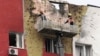 Specialists work on the facade of a damaged apartment building following a drone attack in Moscow, March 11, 2025.