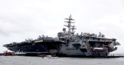 FILE - The U.S. aircraft carrier USS Ronald Reagan is anchored off Manila Bay, Philippines, for a port call, Aug. 7, 2019.