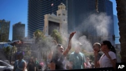 Personas se refrescan en vaporizadores a lo largo del Strip de Las Vegas, el 7 de julio de 2024.