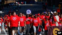 Members of the United Auto Workers walk in the Labor Day parade in Detroit, Sept. 2, 2019. The union's contract with GM has expired and a strike could happen as early as Sunday.