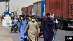 Afghan men walk towards an Afghan-Iran border crossing in Zaranj, Sept. 8, 2021.