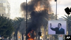 Smoke rises from fire left after clashes between security forces and demonstrators in Tunis, Tunisia, 14 Jan 2011