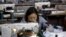 FILE - A garment worker sews clothing at a factoring in Beijing, Oct. 19, 2015. Production in Asian factories barely grew in April. 