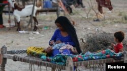 پاکستان میں سیلاب سے متاثرہ ایک بے گھر ہونےوالی خاتون اپنے بچوں کے ساتھ : فوٹو رائٹرز 15ستمبر 2022