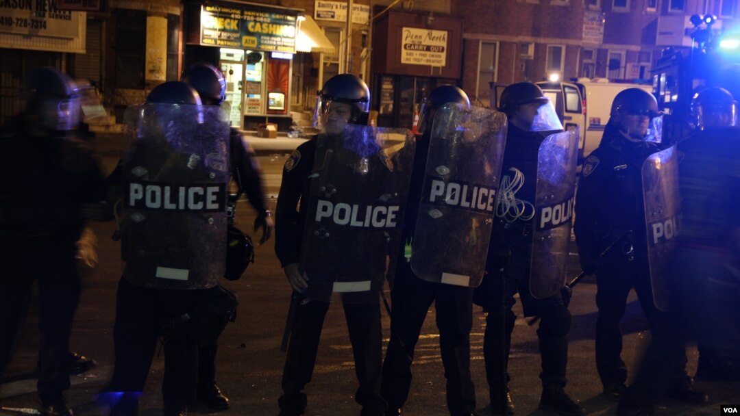 Polisi anti huru-hara membentuk barisan untuk membubarkan para pengunjuk rasa dan media di Baltimore, 28 April 2015. (Victoria Macchi/VOA News)