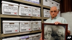 Jack Goins poses with a photo dated to have been taken in 1898 of his great-great grandparents found through genealogical research, May 23, 2012.