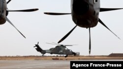 FILE - A French Eurocopter Tiger (Eurocopter EC665 Tigre) helicopter (L) takes off at the French Military base in Gao, Mali, Dec. 5, 2021.