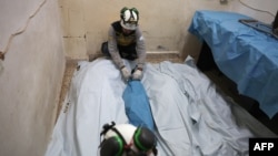 FILE - Syrian Civil Defence volunteers, known as White Helmets, lay the bodies of victims from the same family at a hospital following overnight Russian air strikes near Armanaz town in the northwestern part of Syria's Idlib province on December 26, 2023.