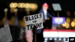 FILE - A supporter holds up a sign as Republican presidential candidate former President Donald Trump speaks at a campaign rally at Trump National Doral Miami, in Doral, Florida, July 9, 2024.