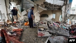 Сотрудник Организации Объединенных Наций проверяет школу ООН, пострадавшую во время израильской бомбардировки в Нусейрате, в центральной части сектора Газа, 6 июня 2024 года