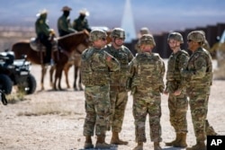 Para prajurit Angkatan Darat mengobrol sambil menunggu kedatangan Menteri Pertahanan Pete Hegseth di perbatasan AS-Meksiko di Sunland Park, N.M., Senin, 3 Februari 2025. (Foto AP/Andres Leighton)