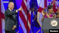 Roslyn M. Brock (R), who chairs NAACP's National Board of Directors applauds as U.S. VP Joe Biden is introduced at their convention, Houston, Texas, July 12, 2012. 