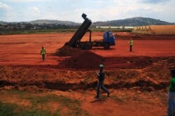 FILE - Dirt is cleared and dumped, destroying a wetland in Entebbe, Uganda, July 8, 2013.