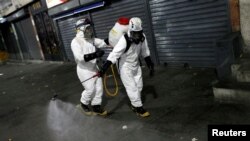 Des travailleurs en combinaisons de protection désinfectent les rues pendant la quarantaine nationale en réponse à la propagation de la maladie à coronavirus, Caracas, Venezuela, 22 mars 2020. (Reuters/Manaure Quintero)