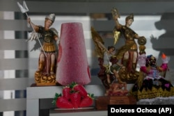 A cutout of a popsicle adorns a shelf next to a statue of patron saint Michael the Archangel in Salcedo, Ecuador, Thursday, Nov. 28, 2024. (AP Photo/Dolores Ochoa)