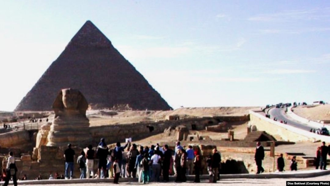 FILE - Tourists are gathering around the Sphinx, which guards the Great Pyramid of King Cheops at the Giza necropolis just outside Cairo, Egypt. (D. Bekheet/VOA)