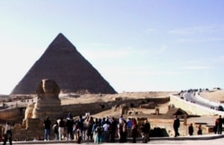 FILE - Tourists are gathering around the Sphinx, which guards the Great Pyramid of King Cheops, home of the ancient wooden solar boat, at the Giza necropolis just outside Cairo, Egypt. (photo: Diaa Bekheet)