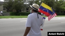 Un residente venezolano ondea la bandera estadounidense y venezolana en un acto de campaña a favor de Joe Biden en Miami, Florida. [Foto: Antoni Belchi/VOA]