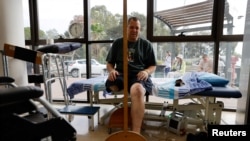 FILE - Avida Bachar from Kibbutz Beeri, uses a mirror as part of his treatment after he lost a leg during the deadly October 7 Hamas attack on the kibbutz, that claimed the lives of his wife and son, in Ramat Gan, Israel, November 13, 2023