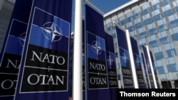 FILE - Banners displaying the NATO logo are placed at the entrance of new NATO headquarters during the move to the new building.