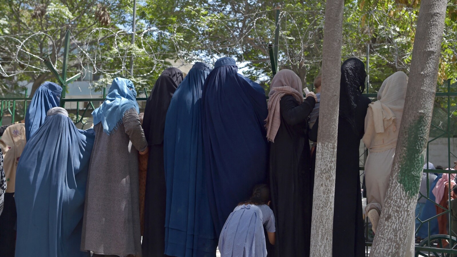 Internally displaced Afghan women, who fled from the northern province due to battle between Taliban and Afghan forces, gather to receive free food being distributed at Shahr-e-Naw Park in Kabul on Aug. 13, 2021. 