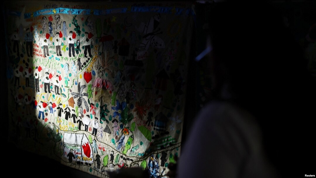 ARCHIVO: Una manta bordada por miembros de Madres de Falsos Positivos (MAFAPO) cuelga en una pared durante un homenaje realizado por la JEP a las víctimas de ejecuciones extrajudiciales llevadas a cabo por el ejército colombiano, en Bogotá, Colombia, el 28 de noviembre de 2024.