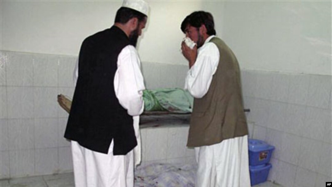 Afghans stand by bodies of people killed in a bombing in a mosque in Taloqan, north of Kabul Afghanistan, 08 Oct 2010
