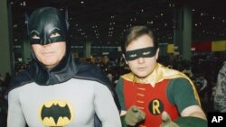 Les acteurs Adam West, à gauche, et Burt Ward, habillés en Batman et Robin, posent pour une photo lors du salon automobile "World of Wheels" à Chicago, le 27 janvier 1989. 