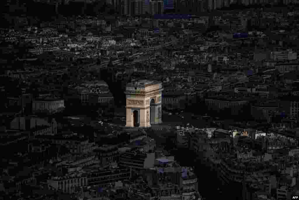 A ray of light shines on the Arc de Triomphe in Paris, France.