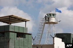 FILE - Peacekeepers from the U.N. Interim Force in Lebanon man an observation point along the so-called blue line on the border between Lebanon and Israel, near the southern Lebanese town of Marwahin, Oct. 12, 2023.