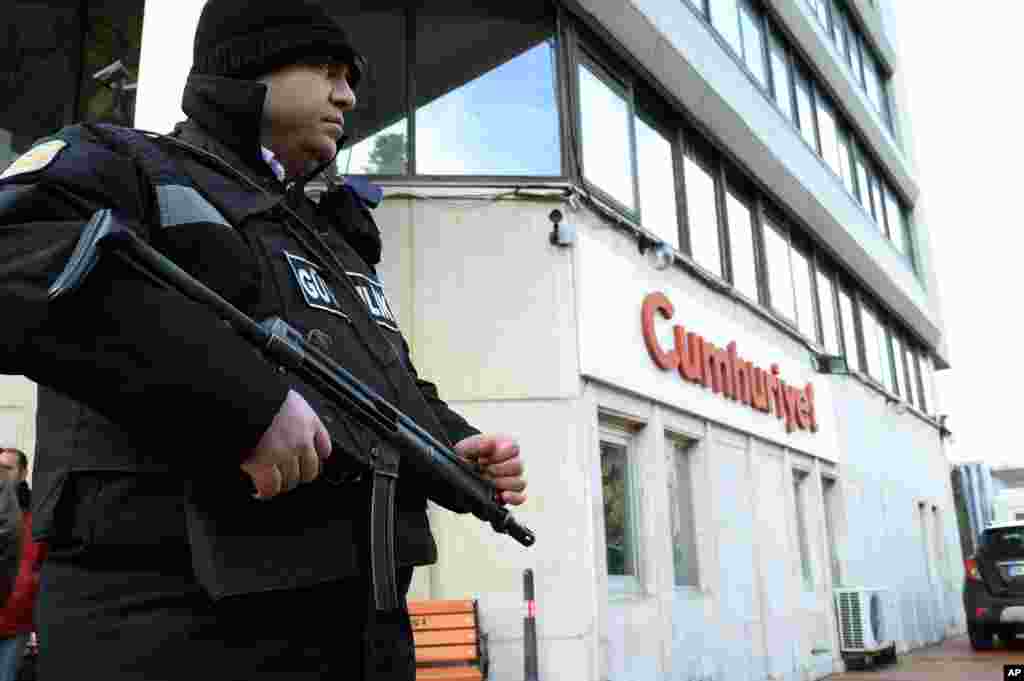 Polisi berjaga-jaga di depan pintu masuk Cumhuriyet, koran Turki pro-sekuler terdepan, di Istanbul, Turki (14/1). (AP Photo)