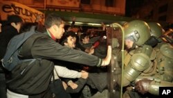 Students scuffle with riot police outside the Education Minister in Santiago, Chile, Tuesday, July 5, 2011.