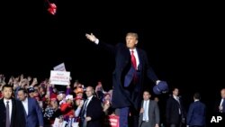 President Donald Trump throws hats to supporters after speaking at a campaign rally at Duluth International Airport, Wednesday, Sept. 30, 2020, in Duluth, Minn. (AP Photo/Alex Brandon)