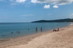FILE - In this March 26, 2020, photo, tourists swim on a beach, Phuket, Thailand.