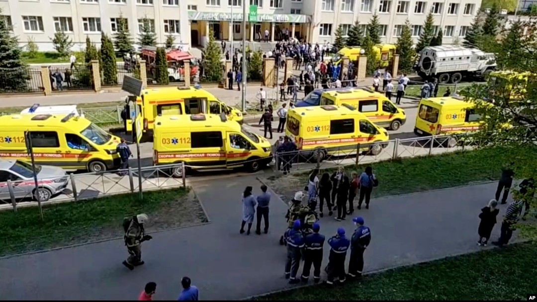 Ambulans dan truk polisi diparkir di sebuah sekolah setelah penembakan, di Kazan, Rusia, Selasa, 11 Mei 2021. Media Rusia melaporkan bahwa beberapa orang telah tewas dan terluka dalam penembakan di sekolah tersebut. (AP Photo)