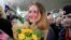 FILE - Convicted Russian agent Maria Butina, who was released from a Florida prison and then deported by U.S. immigration officials, holds flowers upon her arrival at Sheremetyevo International Airport outside Moscow, Oct. 26, 2019. 