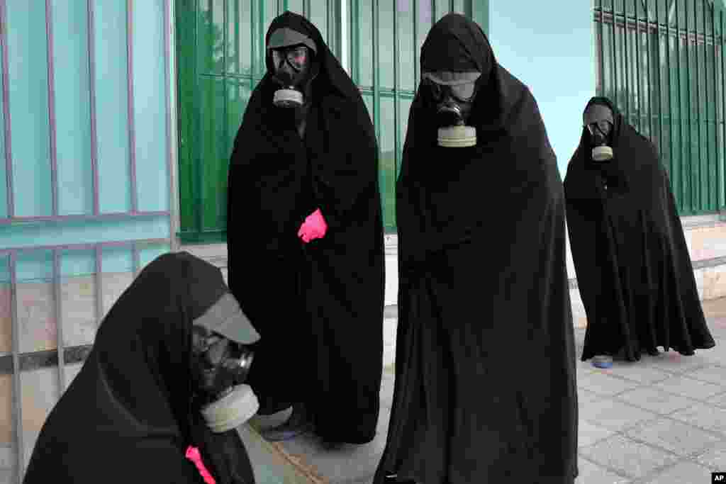 Women clerics wearing protective clothing and "chador," a head-to-toe garment, arrive at a cemetery to prepare the body of a person who died from COVID-19 for a funeral, in Ghaemshahr, Iran, April 30, 2020.