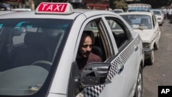 FILE - A taxi driver waits in line for fuel at a gas station, Cairo, Egypt, Sept. 4 2014.