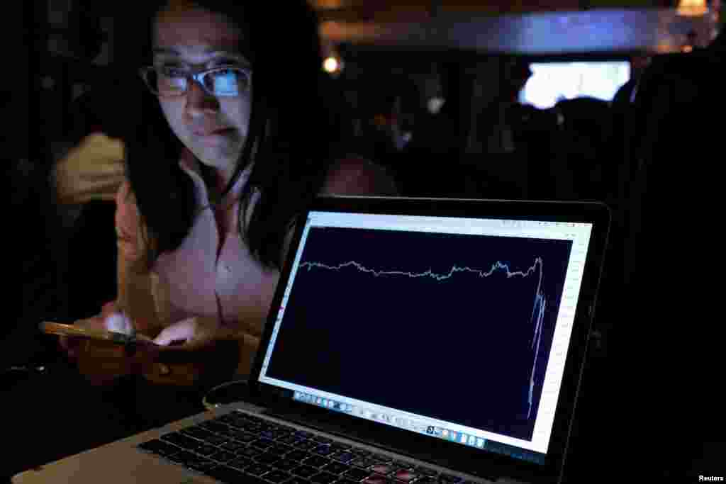 Seorang perempuan yang menonton hasil referendum Brexit di The Churchill Tavern, pub bertema Inggris, di New York, bereaksi sementara sebuah layar menunjukkan grafik kejatuhan nilai pound. (Reuters/Andrew Kelly)